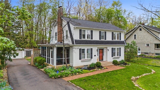 142 Gillett St, Painesville, OH 44077 - dutch colonial with a chimney, an outdoor structure, a shingled roof, a sunroom, and a front yard