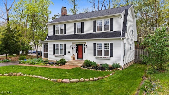 142 Gillett St, Painesville, OH 44077 - view of front facade featuring a front lawn, fence, a shingled roof, and a chimney