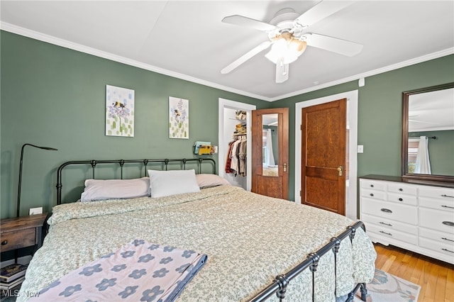 142 Gillett St, Painesville, OH 44077 - bedroom featuring wood finished floors, a closet, ceiling fan, a spacious closet, and crown molding