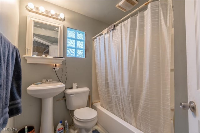 bathroom featuring shower / bath combination with curtain, toilet, and a sink