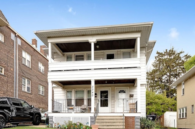 view of front of house with a storage unit, covered porch, and a balcony