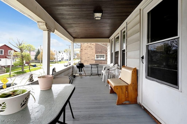 wooden terrace with a porch and a residential view