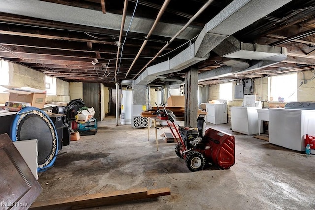 basement featuring gas water heater, separate washer and dryer, and electric panel