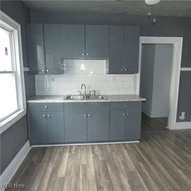 10921 Dove Ave, Cleveland, OH 44105 - kitchen featuring tasteful backsplash, baseboards, dark wood-style floors, and a sink