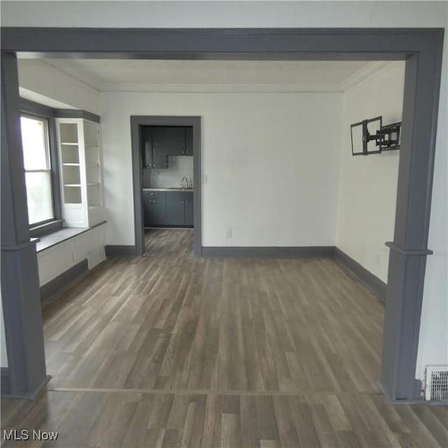 10921 Dove Ave, Cleveland, OH 44105 - empty room with ornamental molding, a sink, visible vents, and wood finished floors