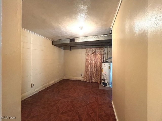 finished basement featuring concrete block wall and gas water heater
