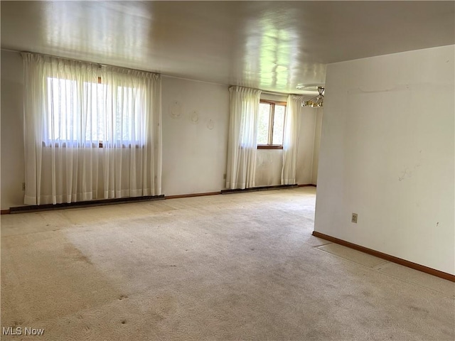 carpeted empty room featuring baseboards