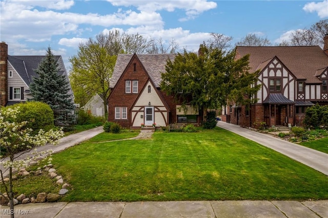 english style home featuring a front yard