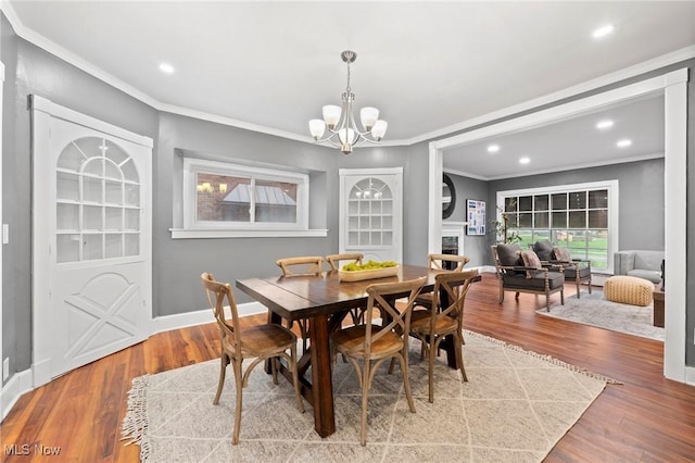 dining room featuring recessed lighting, wood finished floors, a notable chandelier, and crown molding