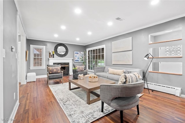 living area with baseboards, visible vents, crown molding, and a baseboard radiator