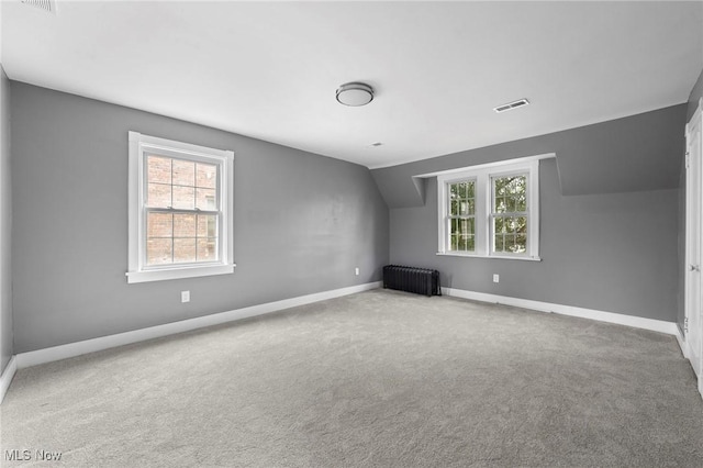 empty room featuring baseboards, visible vents, radiator, and carpet flooring