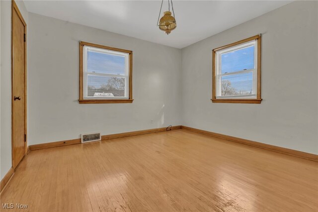 340 53rd St SW, Canton, OH 44706 - empty room featuring a wealth of natural light, visible vents, light wood-type flooring, and baseboards