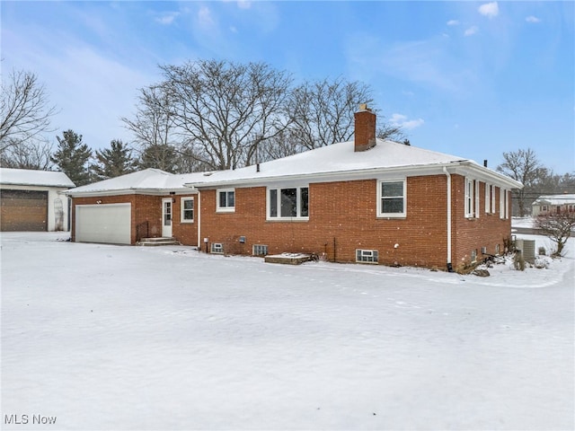 340 53rd St SW, Canton, OH 44706 - snow covered property with a chimney, an attached garage, and brick siding