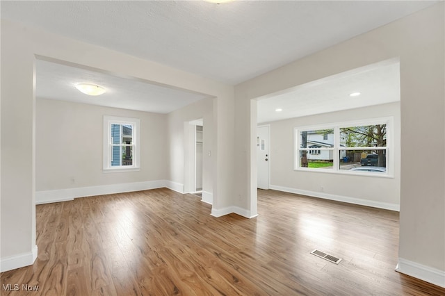 spare room featuring visible vents, wood finished floors, and baseboards