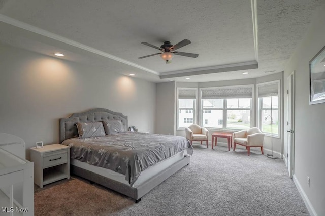 bedroom featuring carpet floors, ceiling fan, baseboards, a textured ceiling, and a tray ceiling
