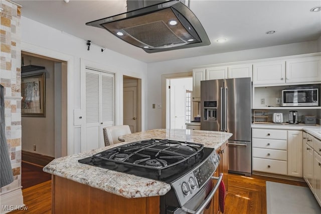kitchen featuring light stone counters, stainless steel appliances, and dark wood finished floors