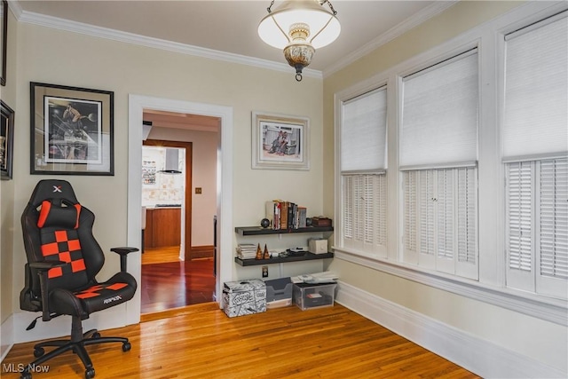 living area featuring wood finished floors, crown molding, and baseboards