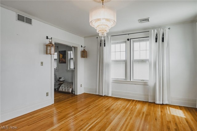 unfurnished dining area with baseboards, visible vents, a notable chandelier, and light wood-type flooring