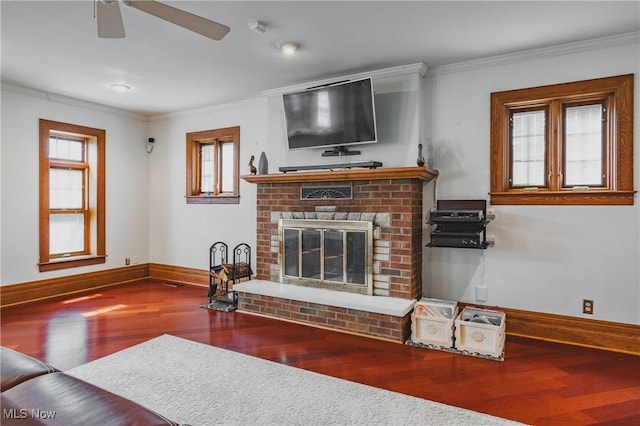 living room featuring ceiling fan, wood finished floors, a fireplace, and crown molding