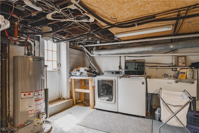 laundry area featuring gas water heater, laundry area, washing machine and clothes dryer, and a sink