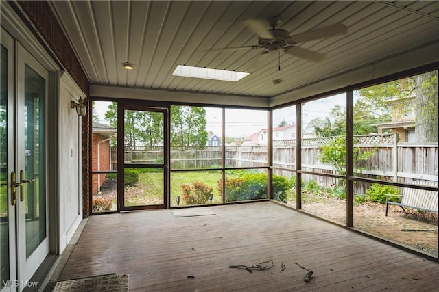 unfurnished sunroom featuring a skylight and a ceiling fan