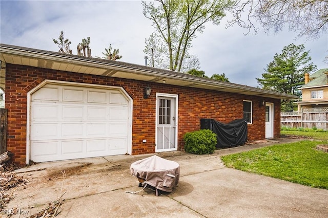 garage with fence and concrete driveway