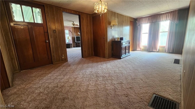 interior space with visible vents, wooden walls, and carpet floors