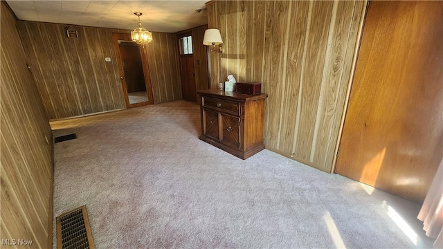interior space with visible vents, wooden walls, and carpet flooring
