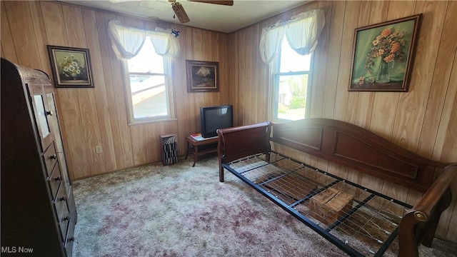 carpeted office space with a healthy amount of sunlight, wooden walls, and ceiling fan