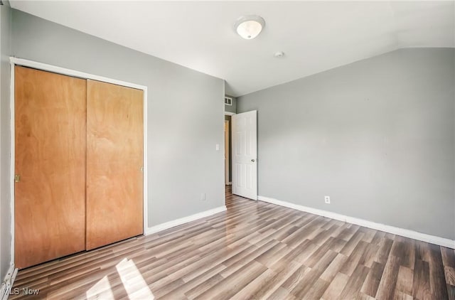 2258 Jacobs Rd, Youngstown, OH 44505 - unfurnished bedroom featuring baseboards, lofted ceiling, wood finished floors, and a closet