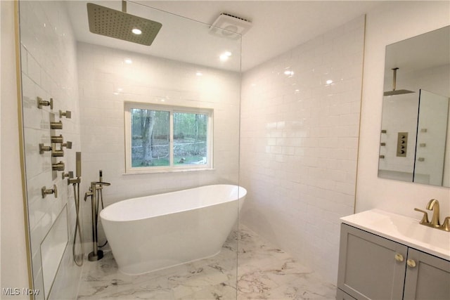 bathroom featuring recessed lighting, vanity, a walk in shower, marble finish floor, and a soaking tub