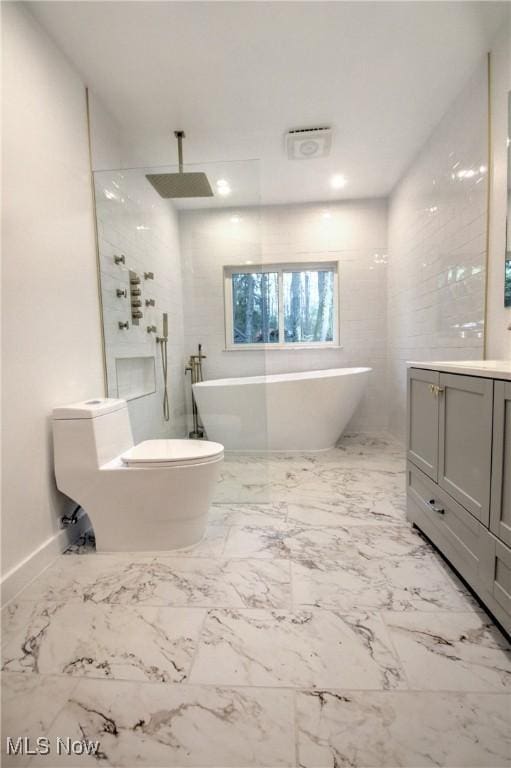full bathroom featuring a soaking tub, marble finish floor, walk in shower, and vanity