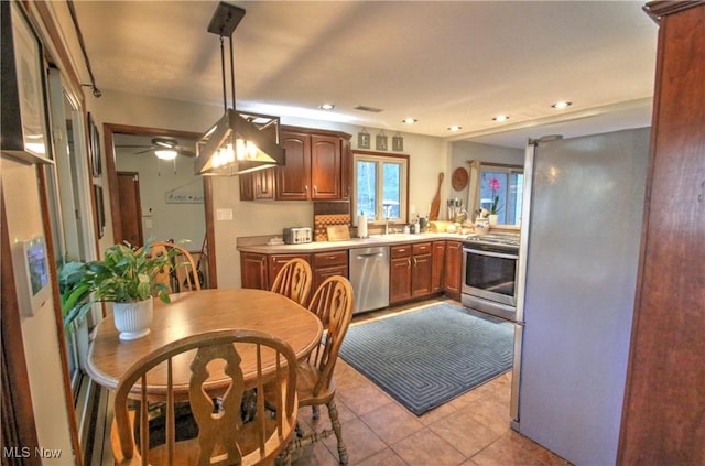 kitchen with recessed lighting, hanging light fixtures, light tile patterned floors, stainless steel appliances, and light countertops