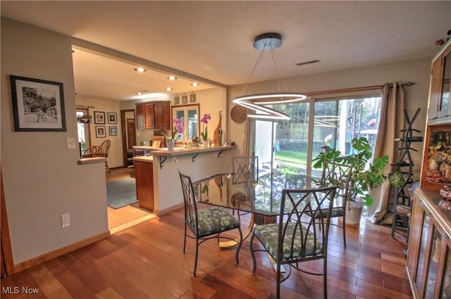 dining space with baseboards, recessed lighting, a notable chandelier, and light wood-style flooring