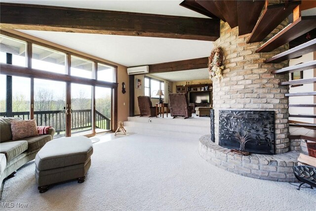living area featuring carpet, a fireplace, a wall mounted AC, and beam ceiling