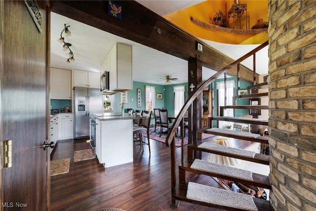 stairs with track lighting, a ceiling fan, and hardwood / wood-style floors