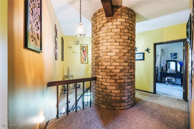 hallway featuring carpet flooring, an upstairs landing, and lofted ceiling