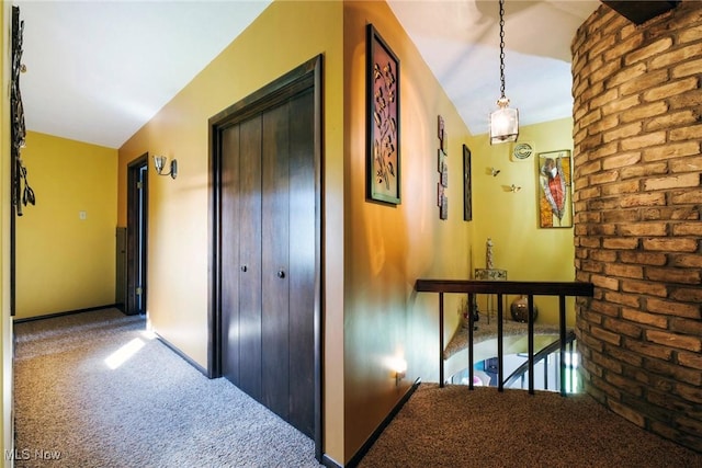 corridor featuring baseboards and carpet