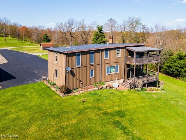 back of property with a lawn and a wooden deck