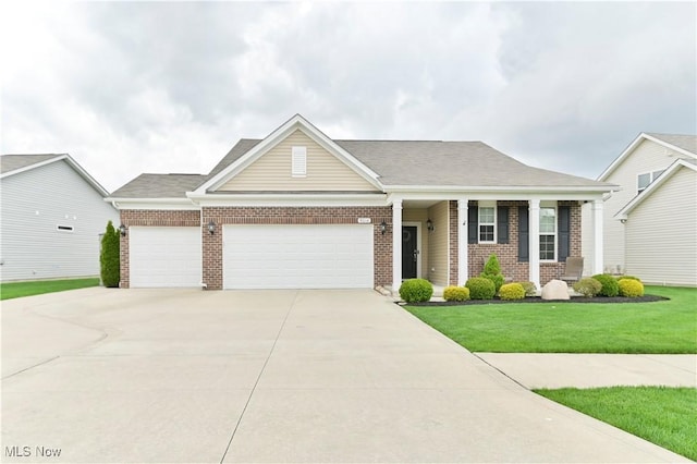 view of front of house with driveway, a front lawn, an attached garage, and brick siding