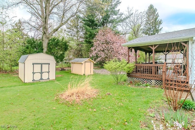 view of yard featuring a deck, a storage unit, and an outdoor structure