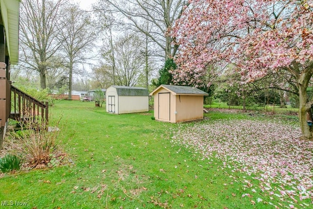 view of yard featuring an outdoor structure, a storage unit, and stairway