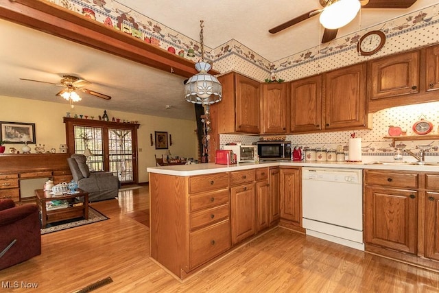 kitchen with a sink, a ceiling fan, open floor plan, and white dishwasher
