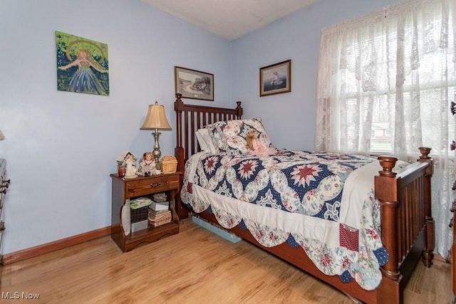 bedroom featuring wood finished floors and baseboards