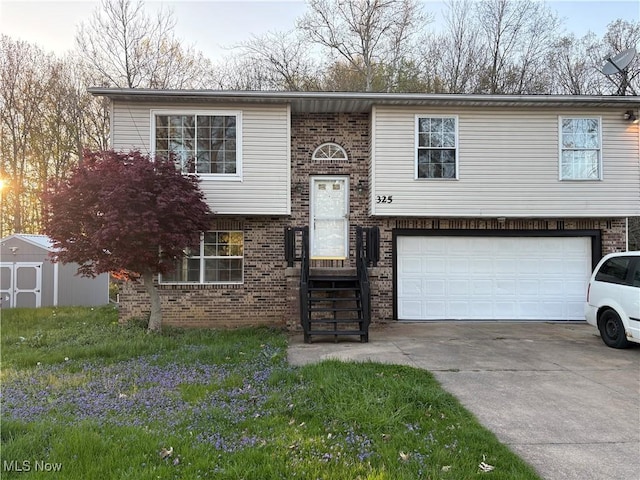 bi-level home featuring a storage shed, concrete driveway, an attached garage, and brick siding