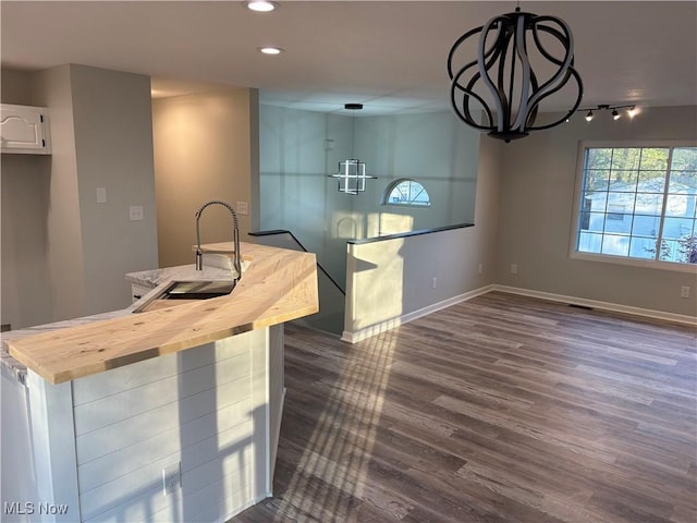 kitchen featuring wood counters, white cabinets, baseboards, recessed lighting, and dark wood finished floors