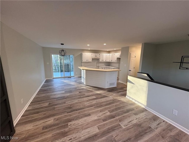 kitchen with white cabinets, a sink, dark wood-style floors, baseboards, and recessed lighting