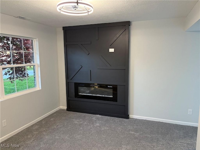 details with baseboards, visible vents, a textured ceiling, and carpet