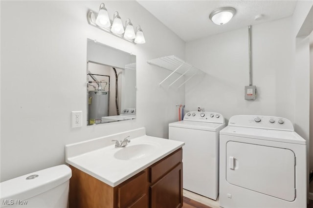 laundry area featuring water heater, separate washer and dryer, laundry area, and a sink