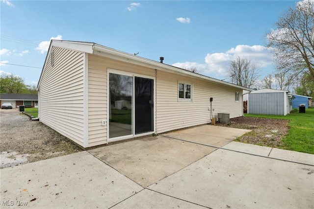 back of property with an outdoor structure and a patio area